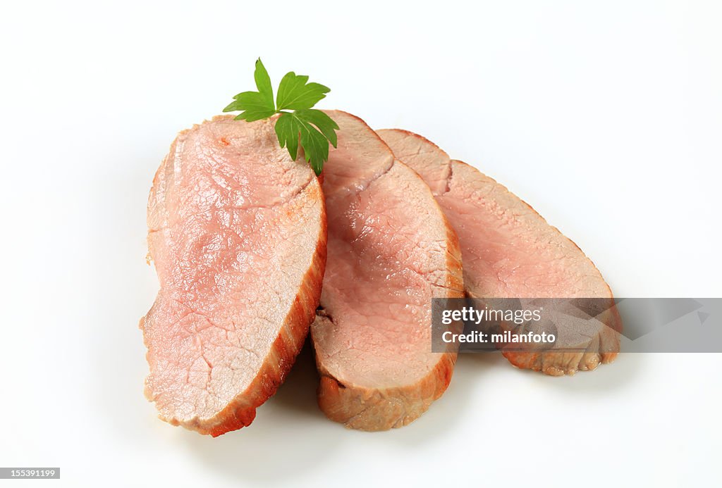 Slices of roasted pork placed on a white background