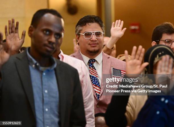 Dwayne Watson, from Costa Rica, wears a patriotic tie as he takes the Oath of Allegiance during a naturalization ceremony in the Rotunda of the State...