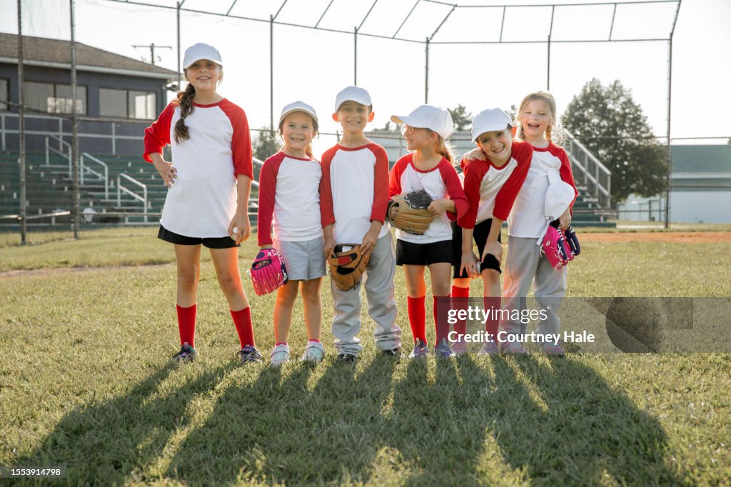 Cute team of baseball players pose for photo on field together