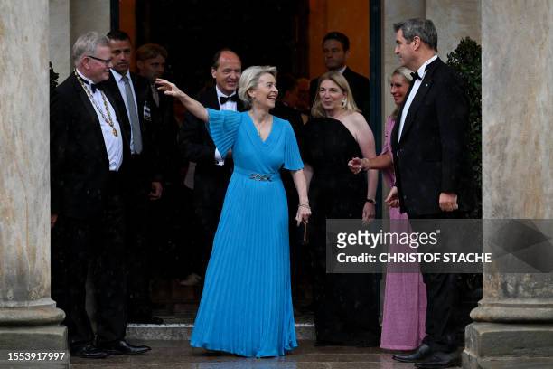 President of the European Commission Ursula von der Leyen reacts upon arrival during rain next to Bavarian State Premier Markus Soeder before the...