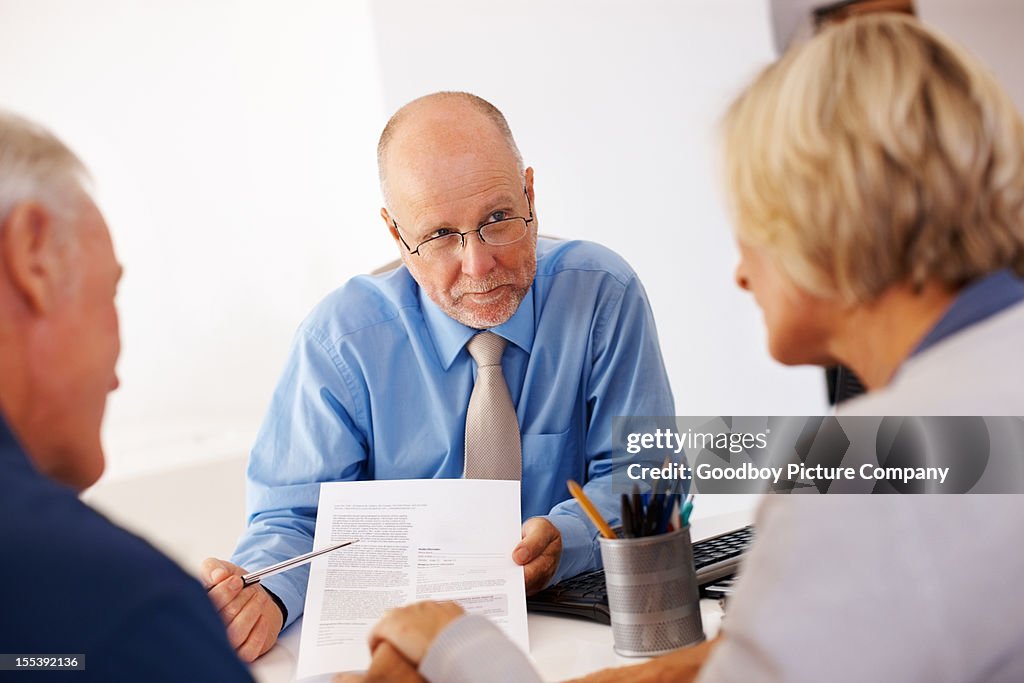 Financial planner showing a form to senior couple