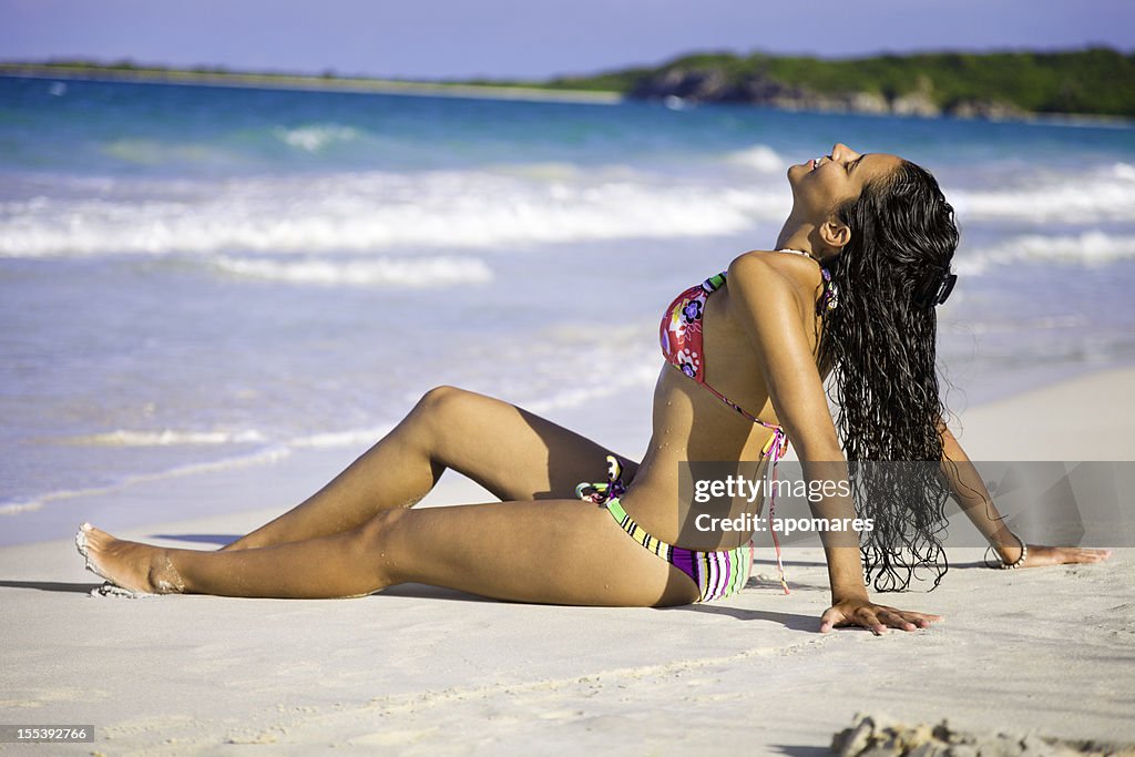 Pretty tanned young woman relaxing on Caribbean beach