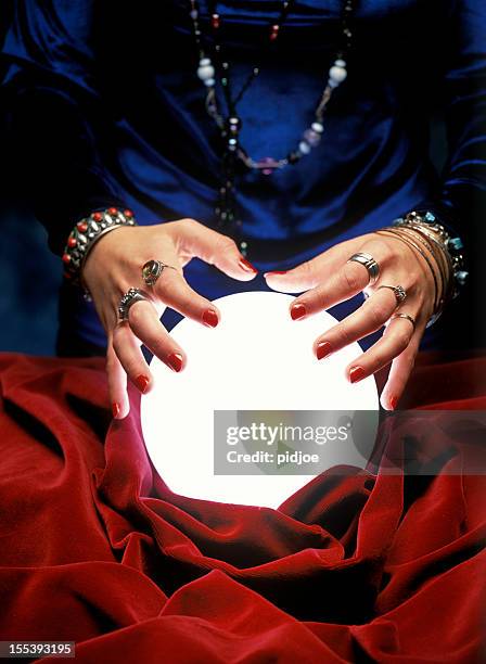fortune teller hands on glowing crystal ball - glazen bol stockfoto's en -beelden
