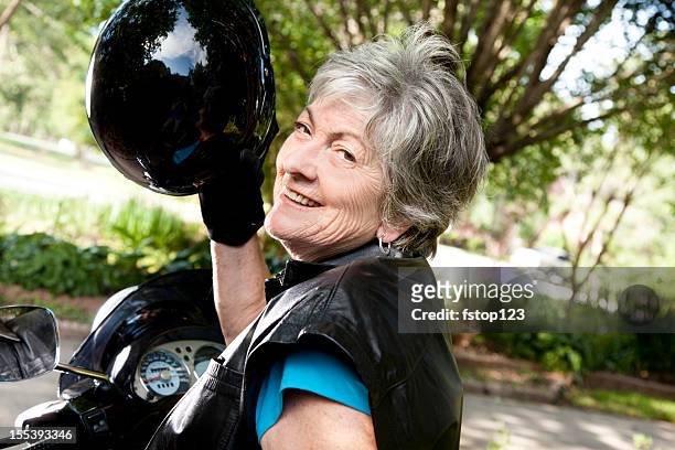senior mujer usando un casco y guantes de cuero, motocicleta chaleco de ciclismo - women black and white motorcycle fotografías e imágenes de stock