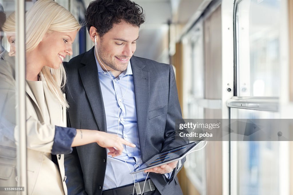 Uomini d'affari in viaggio in treno passeggeri con digital tablet
