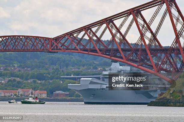 Royal Navy aircraft carrier HMS Prince of Wales sails under the Forth Bridge following the completion of nine months of repairs at Babcock's Rosyth...