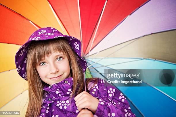 little girl with umbrella - girl face hat raincoat stock pictures, royalty-free photos & images