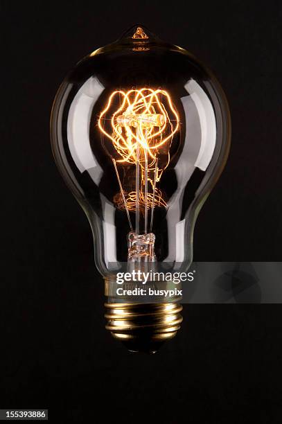 antique lightbulb isolated on black - antique lightbulb stockfoto's en -beelden