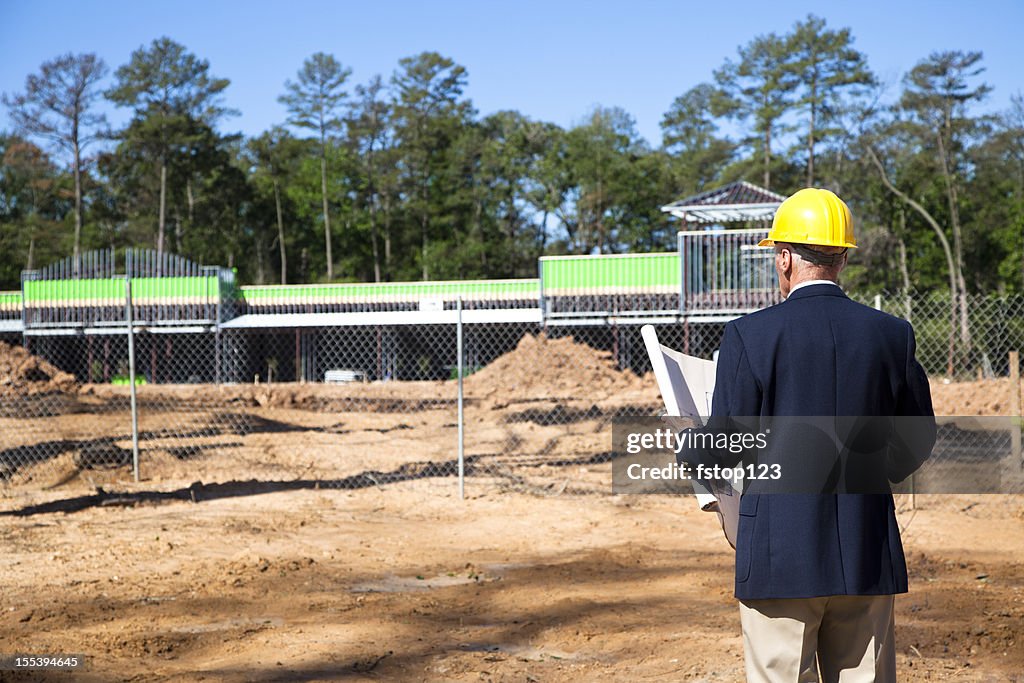 New commercial building construction site with contractor in foreground