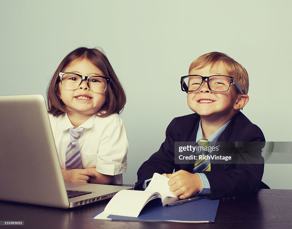 Crianças de negócios com o Laptop no escritório