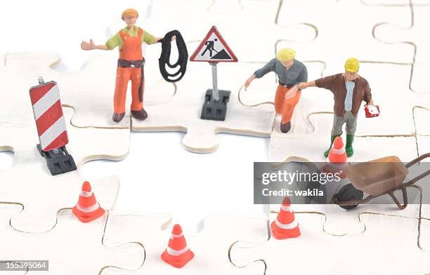 construction worker build on last puzzle piece - figurine stock pictures, royalty-free photos & images