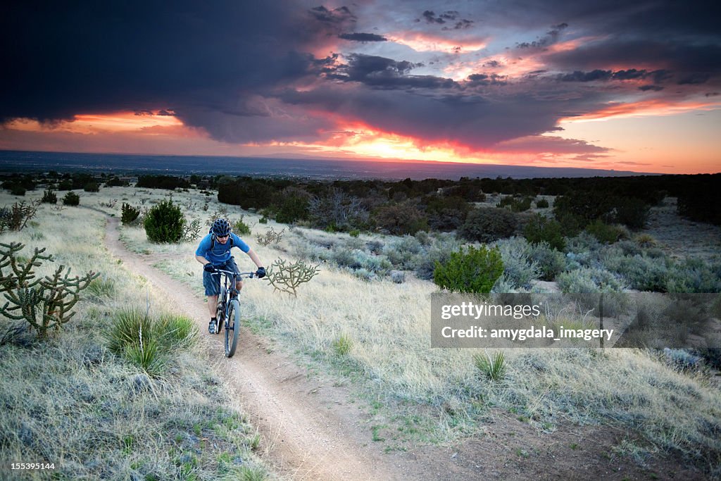 Andar de Bicicleta de montanha dramática céu pôr do sol