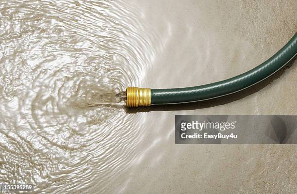 水の浪費 - wet hose ストックフォトと画像