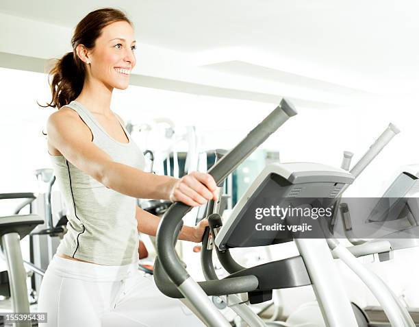 frau in ein fitness-center. - cross trainer stock-fotos und bilder