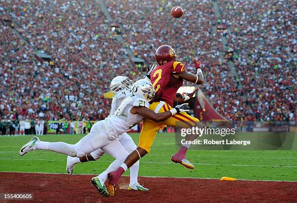 Robert Woods of the USC Trojans scores a touchdown in the first half as Avery Patterson and Erick Dargan of the Oregon Ducks tackle him at Los...
