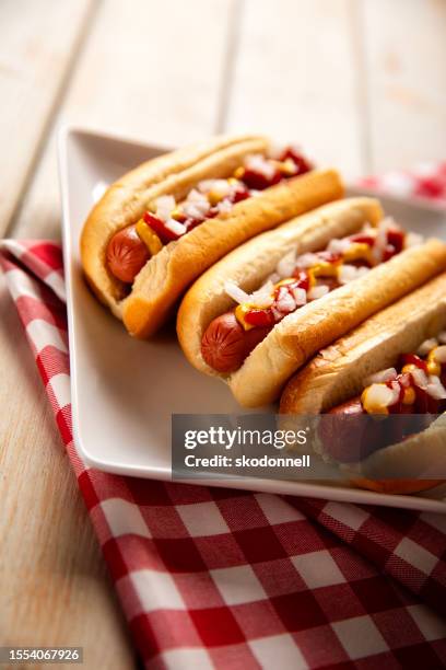 hot dog picnic on white bench - hotdog stockfoto's en -beelden