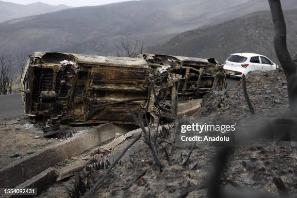 Heavily damaged vehicles are seen as deadly wildfires ravage settlements along the country's Mediterranean coast and firefighters continue their...