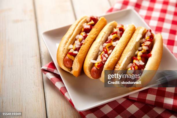 hot dog picnic on white bench - hotdog stockfoto's en -beelden