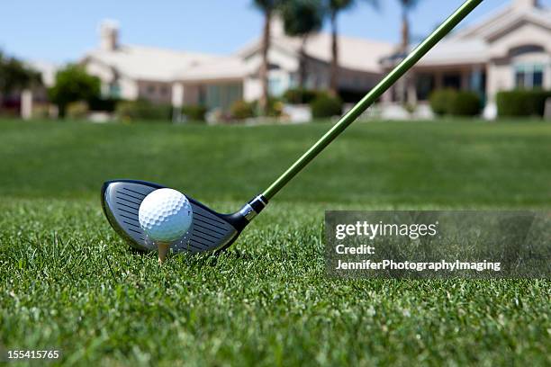 close-up of a golf ball about to be hit in a field - golf clubhouse stockfoto's en -beelden