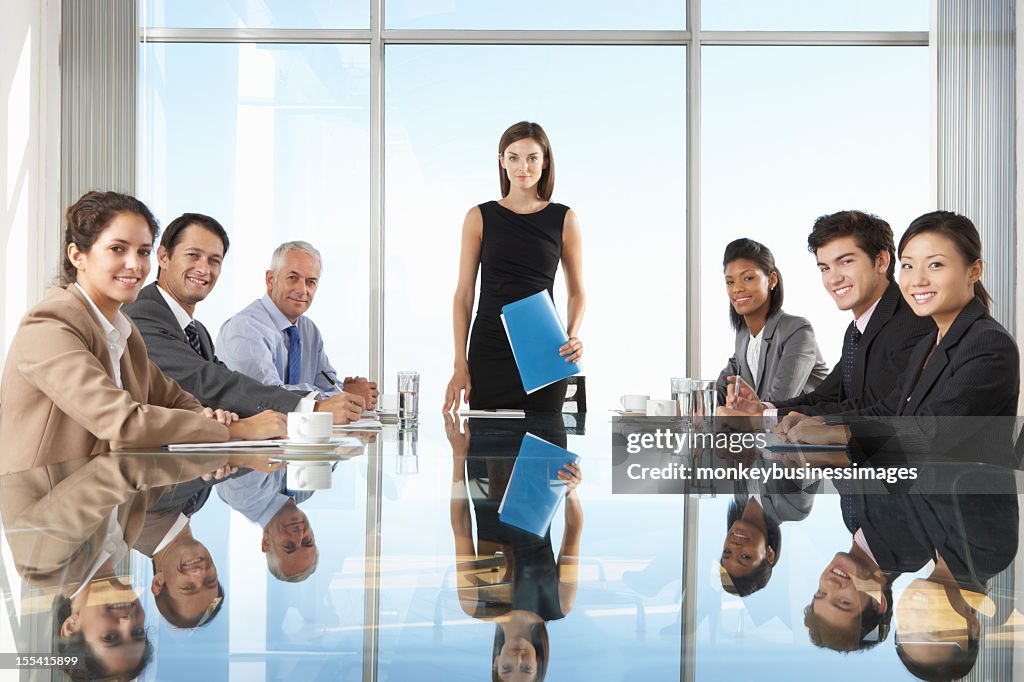 Group Of Business People Having Board Meeting Around Glass Table