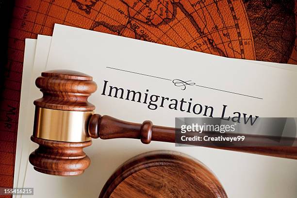 judge's gavel atop an immigration law paper - emigration and immigration stock pictures, royalty-free photos & images