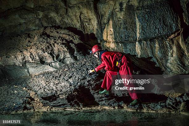 geologist exploring caves deep underground - geoloog stockfoto's en -beelden