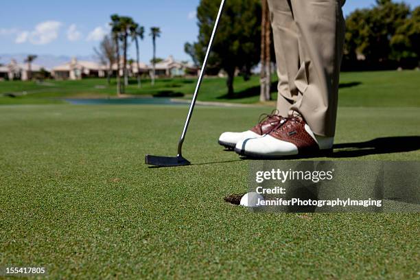 putting a golf ball - golf clubhouse stockfoto's en -beelden