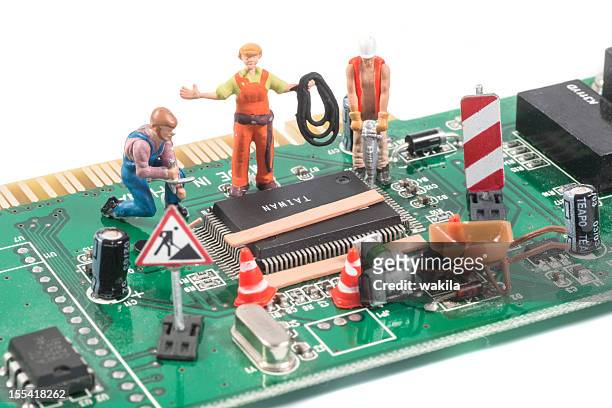 repairing computer equipment with figurines - figurine stockfoto's en -beelden