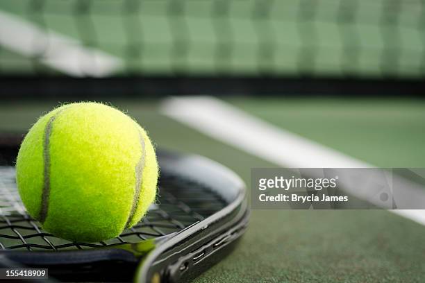 tennis ball and racket on the court horizontal - tennisbal stockfoto's en -beelden