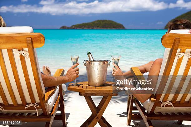 pareja de luna de miel en sillones reclinables bebiendo champán en una playa caribeña - butlins fotografías e imágenes de stock