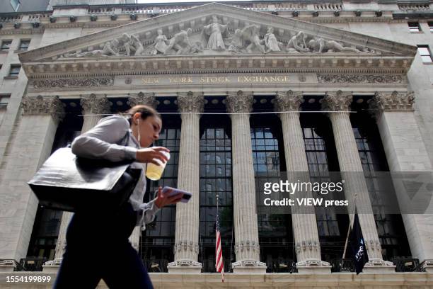 Woman walks near the New York Stock Exchange on July 18, 2023 in New York City.Stocks closed slightly high today as U.S. Central bank officials are...
