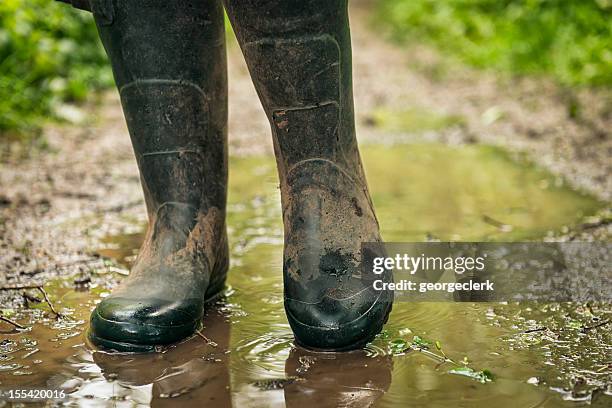 muddy país a pie y con fregadero - botas de agua fotografías e imágenes de stock