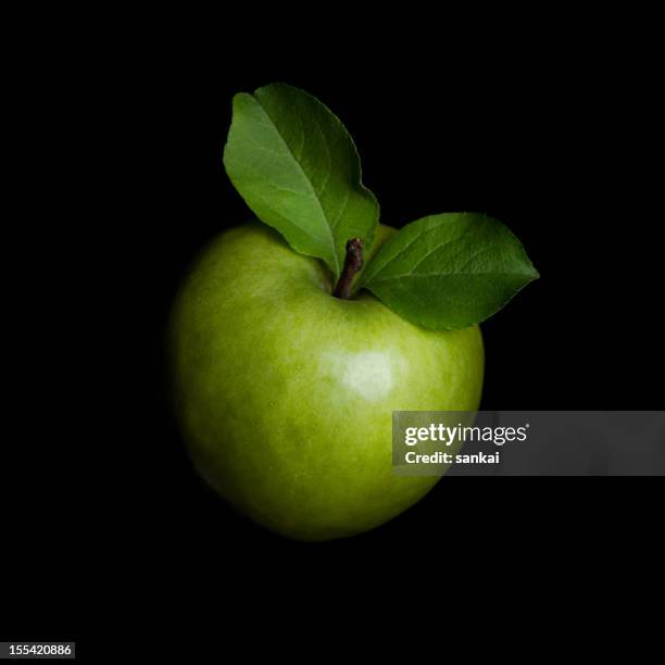 green apple isolated on black background - green apples stockfoto's en -beelden