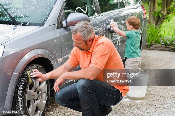 father and son washing car - car splashing water on people stock pictures, royalty-free photos & images