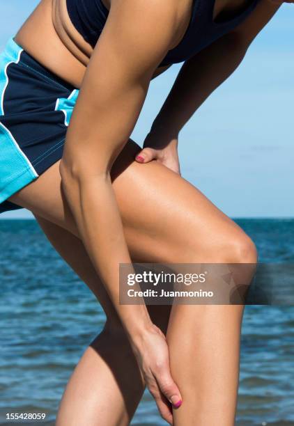 cramp in her calf - female muscular calves stockfoto's en -beelden