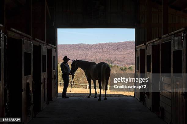 cowboy and horse silhouette in barn door, summer mountain landscape - horse barn stock pictures, royalty-free photos & images