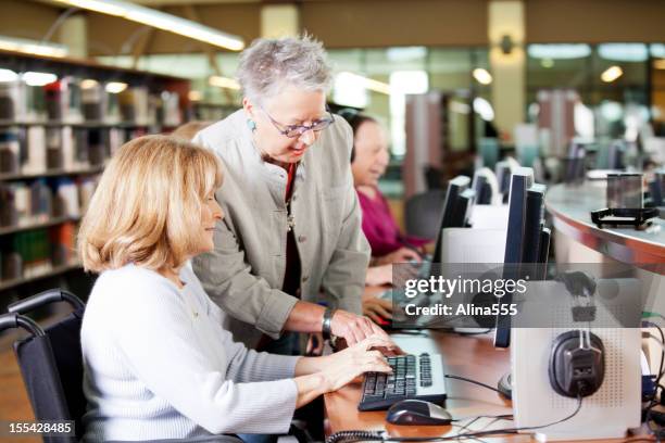 librarian helping a group of seniors working on computers - old computer lab stock pictures, royalty-free photos & images