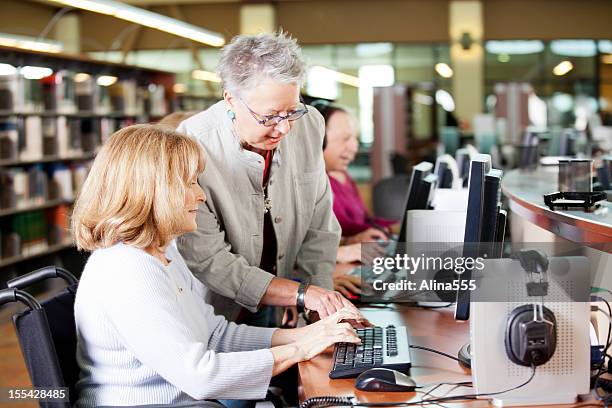 librarian helping a group of seniors working on computers - bibliotekarie bildbanksfoton och bilder