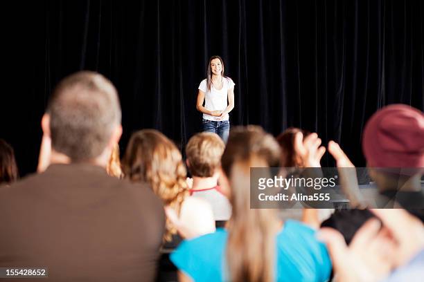 adudience clapping for a teenage girl on stage - awards ceremony stock pictures, royalty-free photos & images