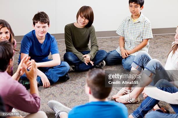 gruppo di giovani ragazzi ascoltando insegnante - bambini seduti in cerchio foto e immagini stock