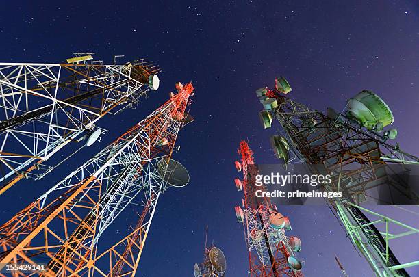 five telecommunication towers under a night sky  - radio waves stockfoto's en -beelden