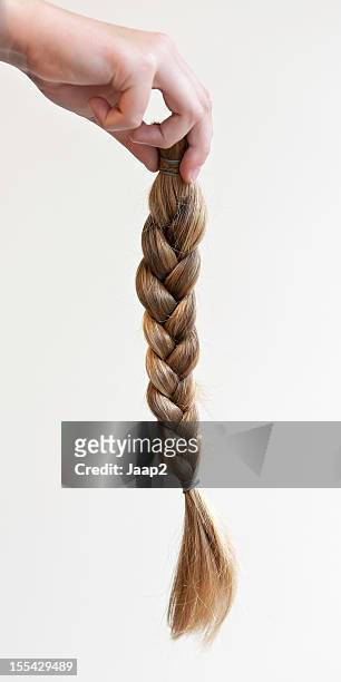 hand holding a braided ponytail cut off for making wig - flätor bildbanksfoton och bilder