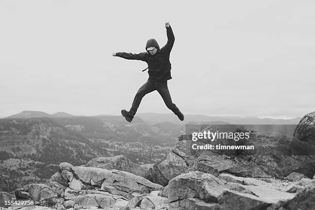 epic man jumping over rocks - black and white landscape stock pictures, royalty-free photos & images