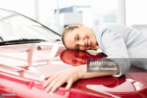 young woman embracing her new car - car love stock pictures, royalty-free photos & images