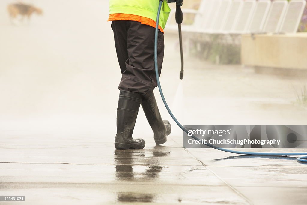 Worker Steam Cleans Sidewalk Dog