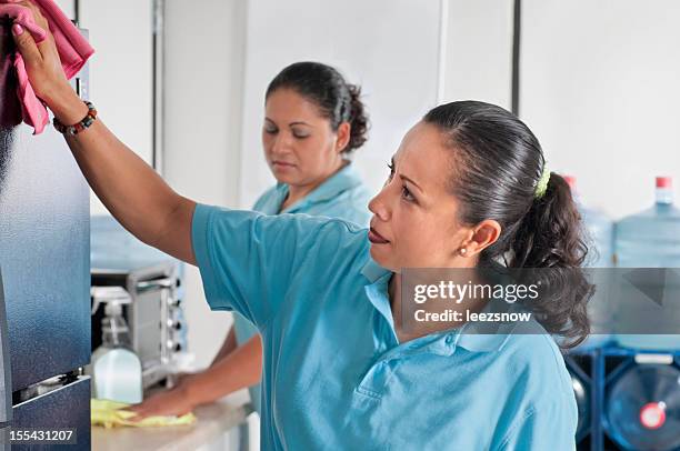 hispanic women cleaning service clean a corporate lunch room - cleaning services stock pictures, royalty-free photos & images