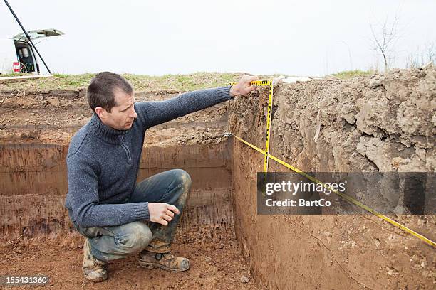 archaeologist using foot measure - archeologie stockfoto's en -beelden