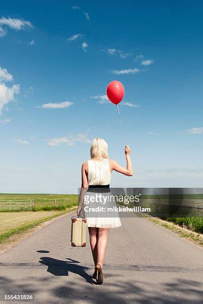 frau geht weg und hält luftballons und koffer - red stiletto shoe stock-fotos und bilder