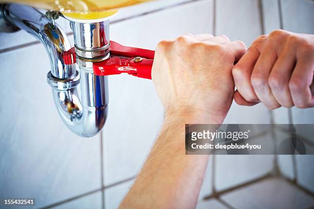 plumber hands holding wrench and fixing a sink in bathroom - repairing stock pictures, royalty-free photos & images