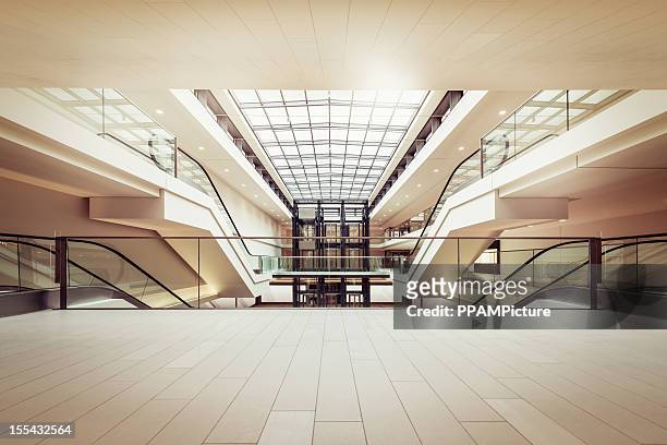 rolltreppen in einem klaren, modernen shopping mall - shoppingcenter stock-fotos und bilder